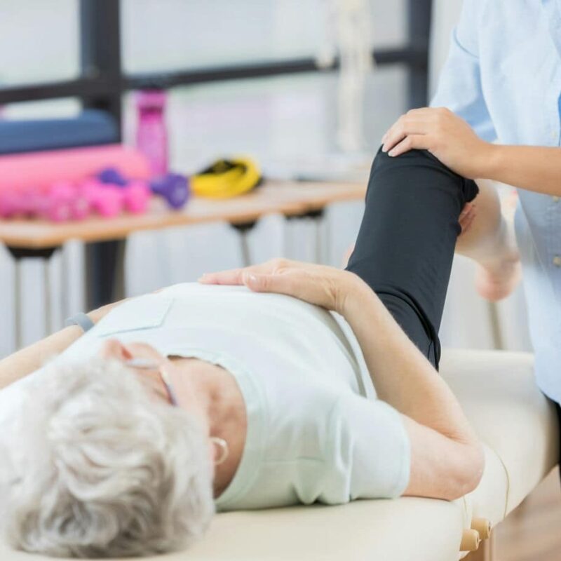 fizjoterapeuta ćwiczący ze starszą kobietą