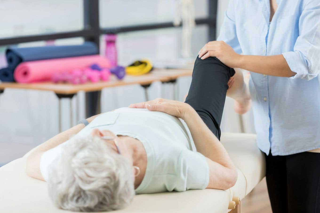 fizjoterapeuta ćwiczący ze starszą kobietą